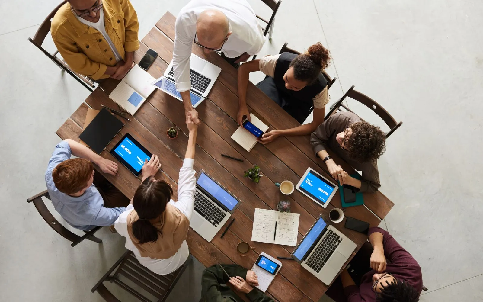 A team working together around a large table, seen from above, with laptops and notes.