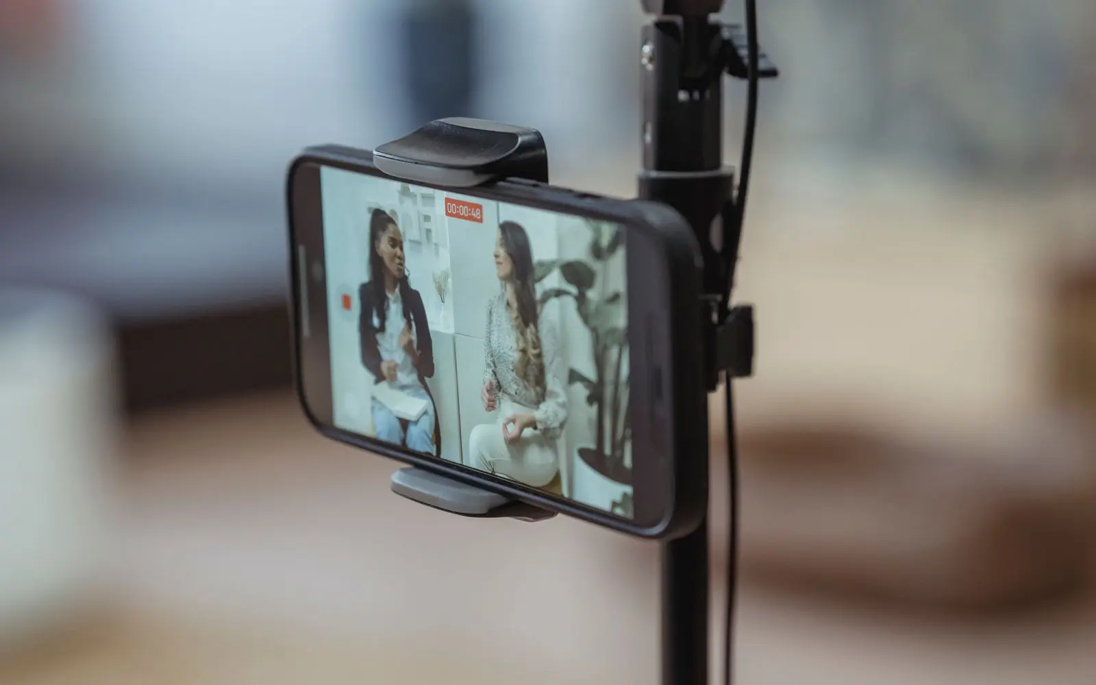 A phone on a stand recording, its screen showing the room in front of it.