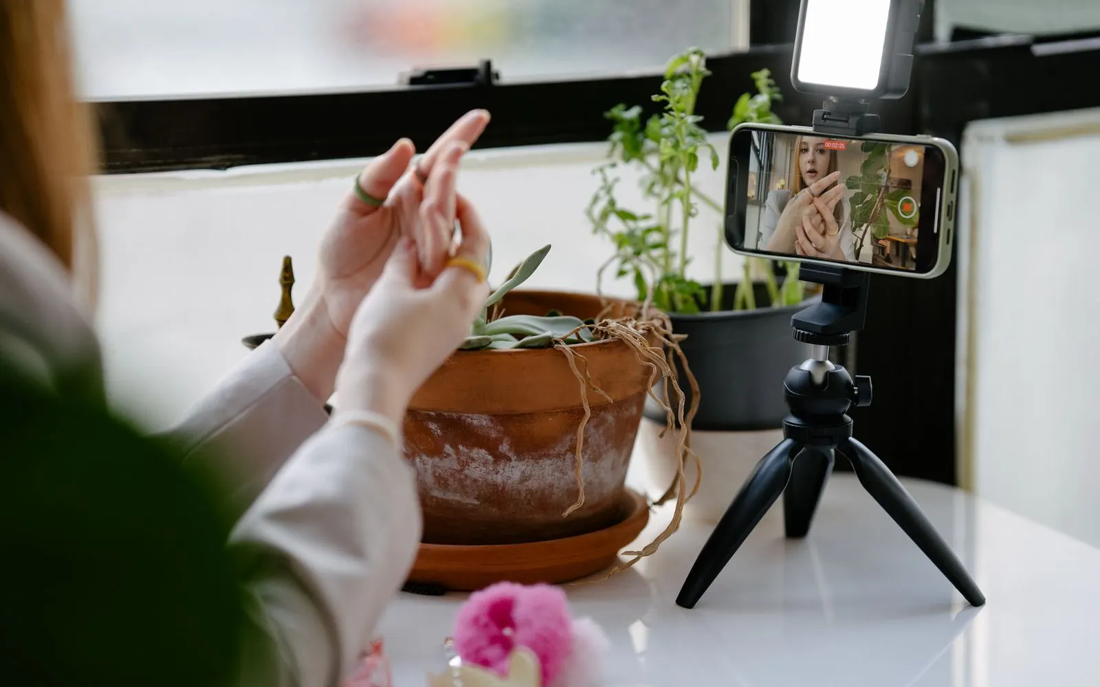 A phone mounted on a small tripod filming a shoot in progress at home.